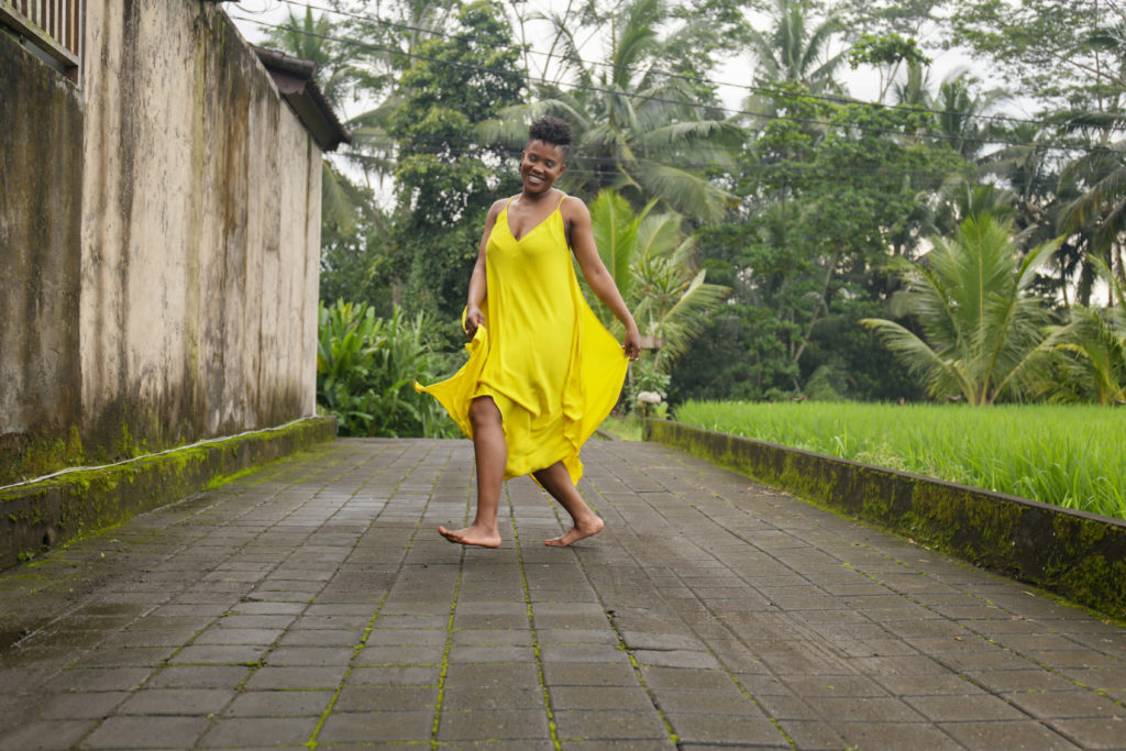 Anastasia White dancing with a yellow dress surrounded by nature