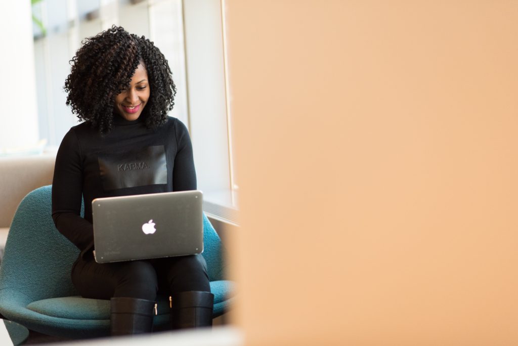 Black woman typing on a laptop.