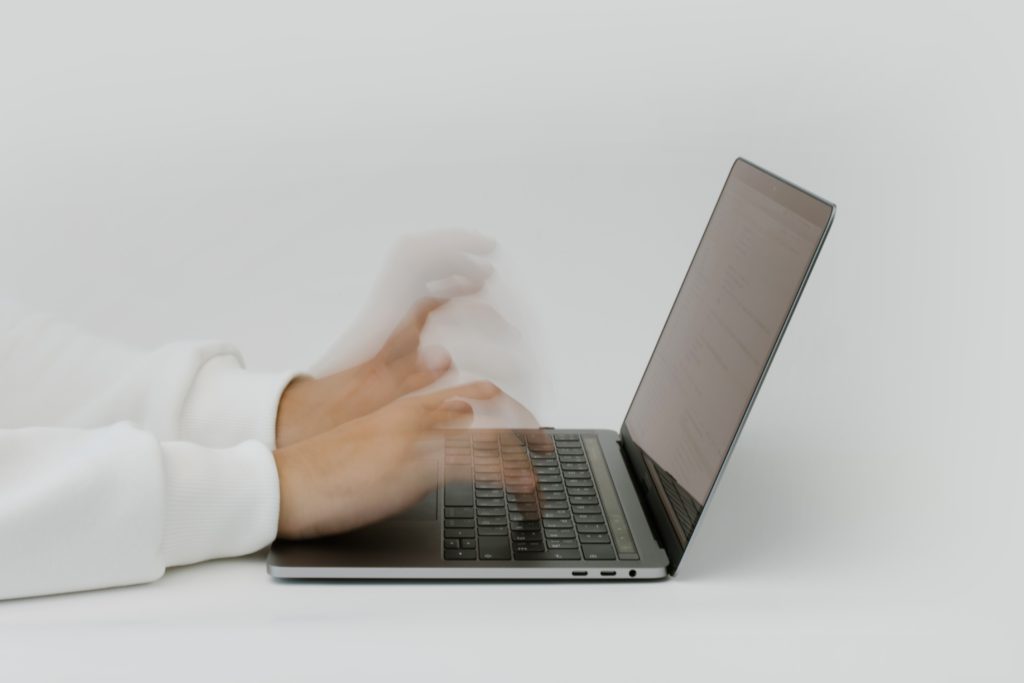 Person speed typing on a laptop.