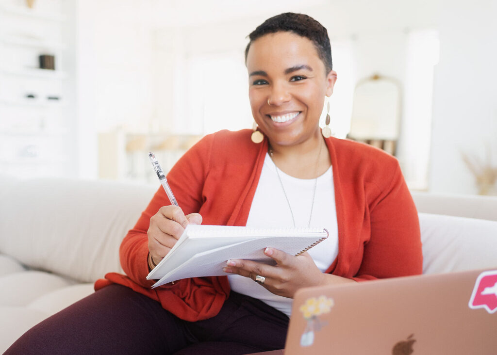 Shanté smiling and holding a pen and notebook